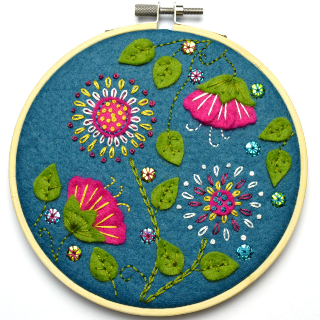 Corinne Lapierre applique hoop felt tropical flowers craft kit. Pink flowers, green leaves, set in a wooden embroidery hoop.