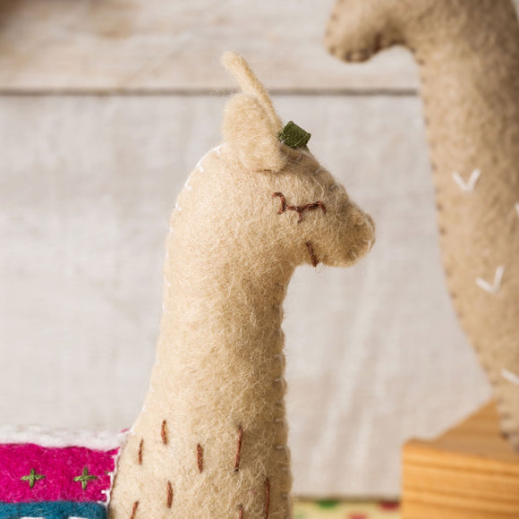 Corinne Lapierre Felt Llamas Craft Kit. A colourful scene. There are 3 Llamas. All three Llamas are wearing multi coloured waistcoats. 