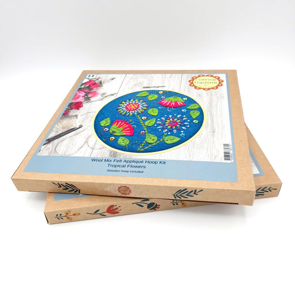 Corinne Lapierre applique hoop felt tropical flowers craft kit. Pink flowers, green leaves, set in a wooden embroidery hoop.